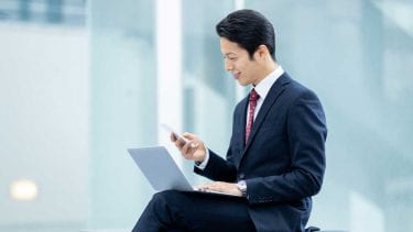 スマホを見る男性の画像