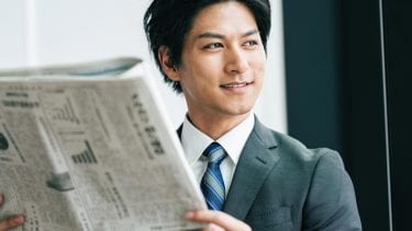 新聞を読むオフィスワーカーの画像